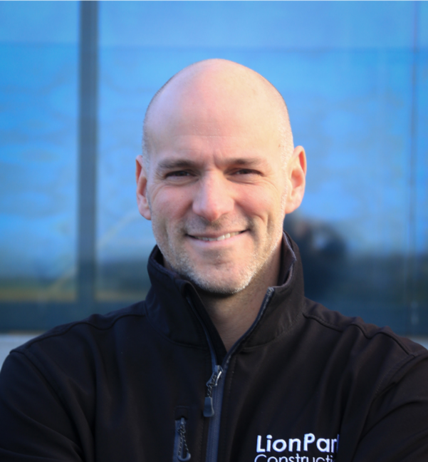 Bald man smiling in black jacket